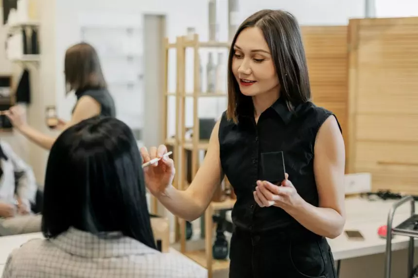 The makeup artist works in her salon, applies professional makeup