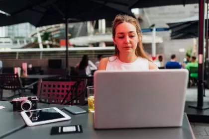 Young business woman digital nomad freelance blogger outdoors working using computer