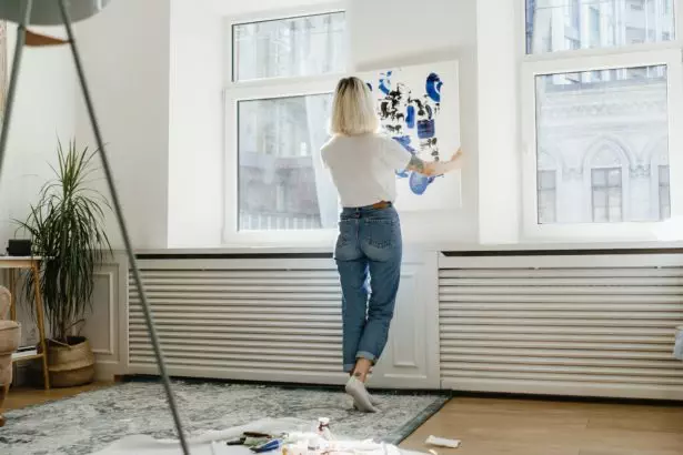 Young woman placing abstract paint on the wall