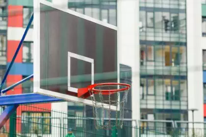 Basketball ring on a closed court in the courtyard of a multi-storey building.