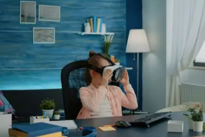 Little schoolgirl using vr glasses for virtual reality learning