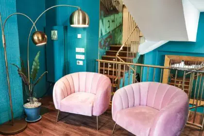 Pink couches and plant in the entrance of a restaurant, wooden floor, modern interior design