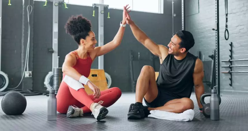 High five woman, personal trainer man for fitness goal in gym or training facility together. Succes