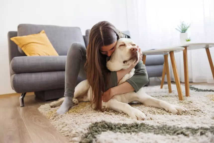 Woman cuddling and hugging her pet dog